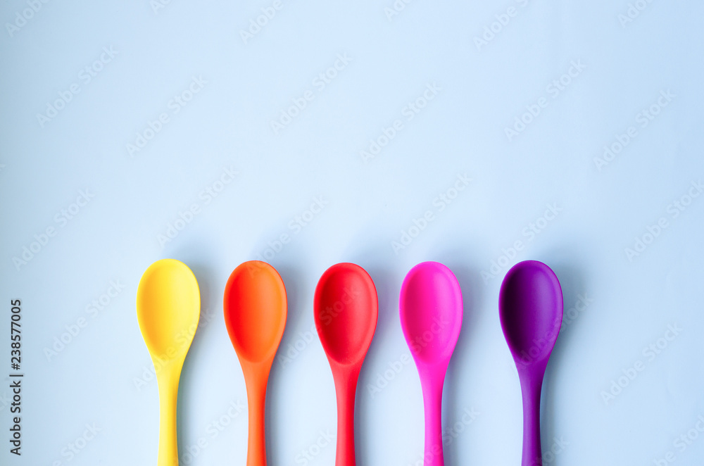Fletley from multi-colored spoons on a blue background. Fletley from multi-colored spoons on a blue background.