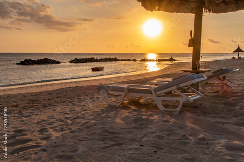 Sonnenuntergang am Meer in Mauritius mit Sonnenliege und Sonnenschirm