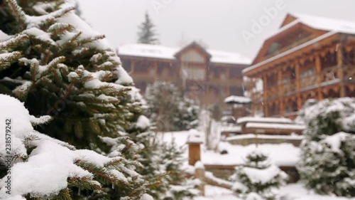 Wallpaper Mural Snow falling fir tree branches, wooden cottages on background. Heavy snowfall at mountain village ski resort. Cold frosty winter day in mountains. Authentic landscape design with spruce and bushes. Torontodigital.ca