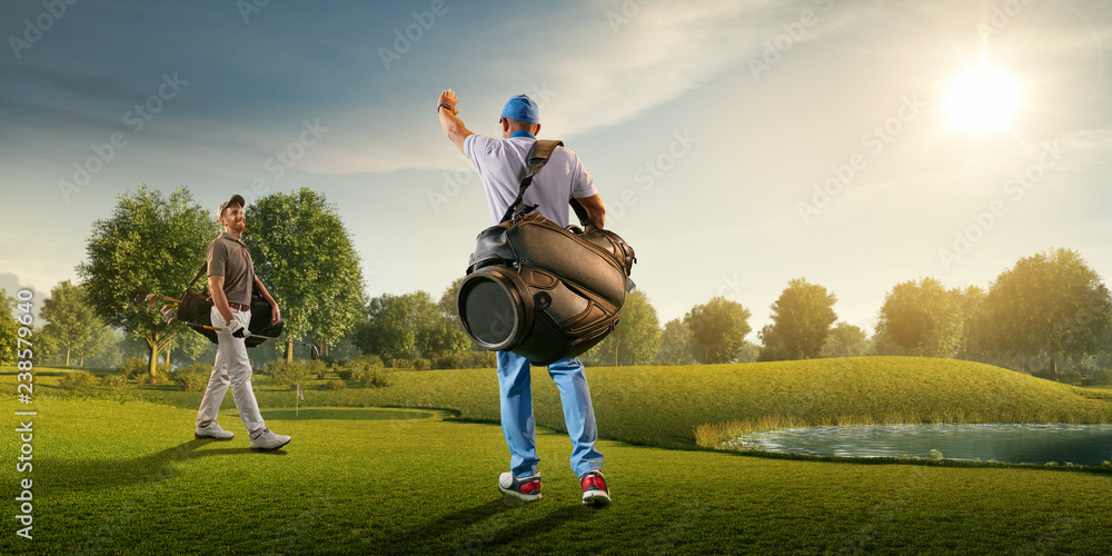 Two male golf players on professional golf course. Smiling golfers walking with golf clubs and golf bags