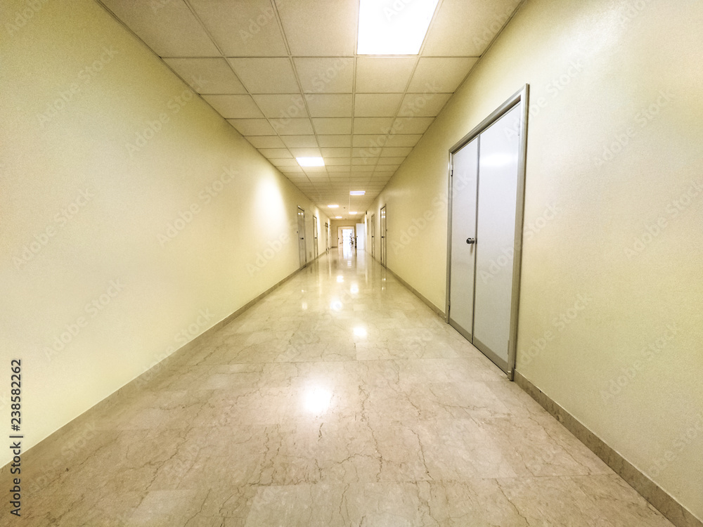Generic white walkway corridor with white walls of a hospital lane interior. Blurred medical and healthcare background.