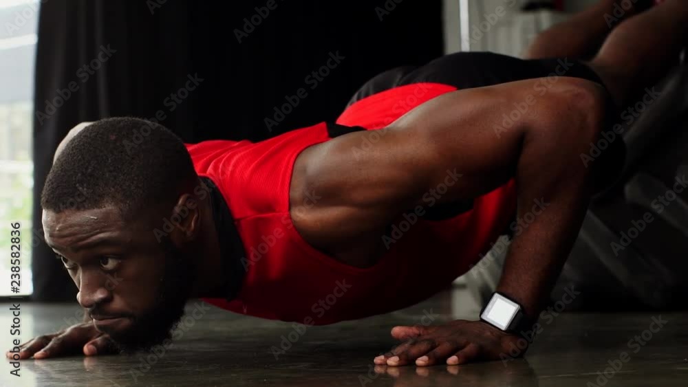 african american sportsman doing push ups at gym in slow motion