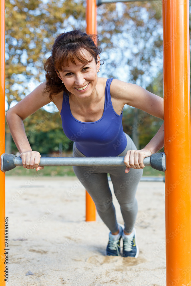 Fototapeta premium Woman pushing up during outdoor training