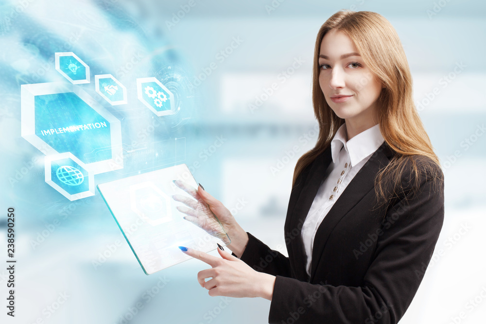 The concept of business, technology, the Internet and the network. A young entrepreneur working on a virtual screen of the future and sees the inscription: Implementation The concept of business, technology, the Internet and the network. A young entrepreneur working on a virtual screen of the future and sees the inscription: Implementation