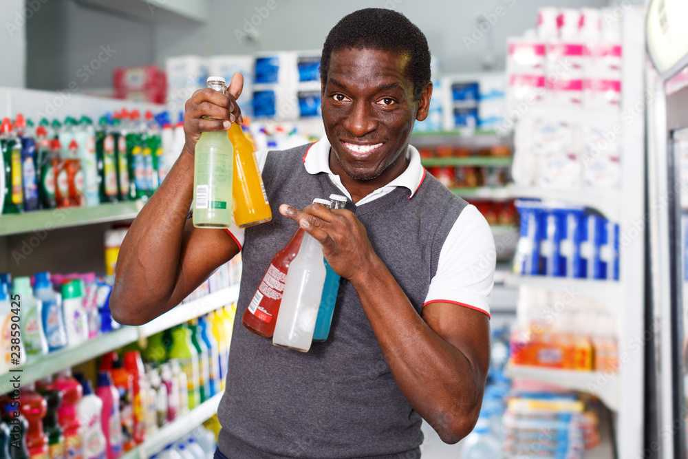African man choosing drinks in store