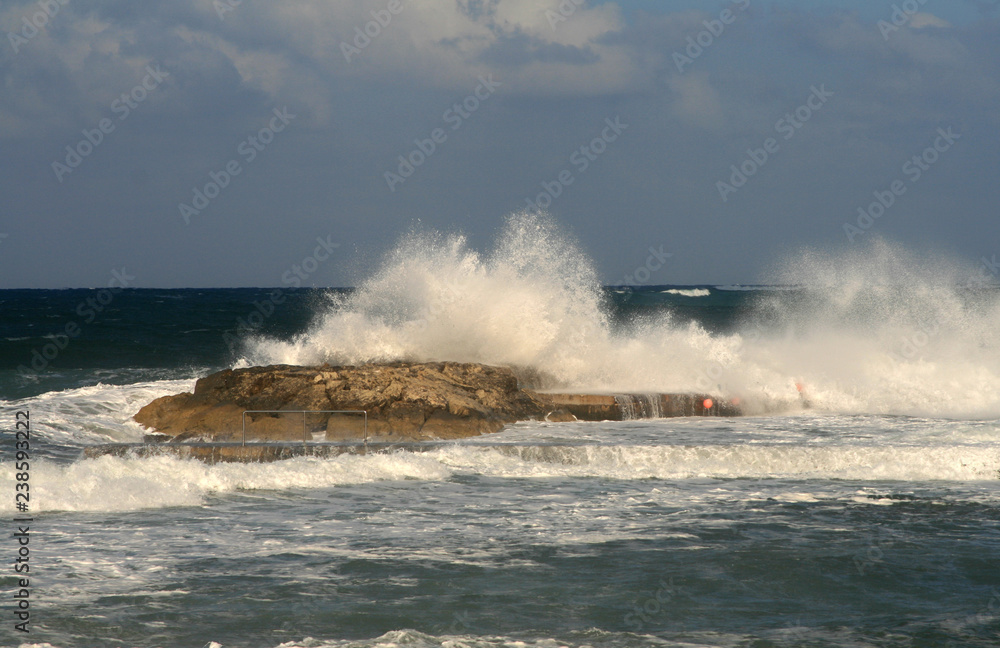 Large waves breaking on a rock by the Mediterranean sea coast