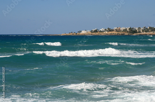 White foamy waves on a rocky shore of the Mediterranean sea
