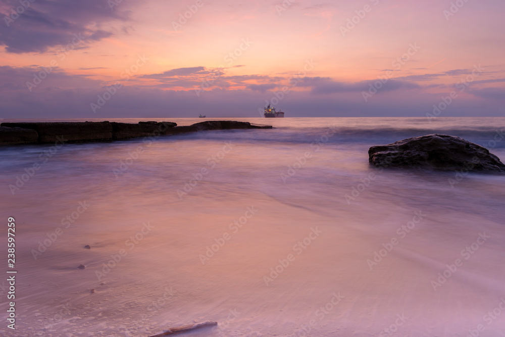 Sunrise over the sea - water, sand and ship.