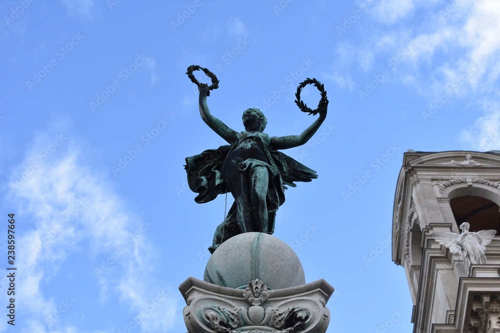 Statue of winged woman holding laurel wreath in front of Art museum in Vienna. The Greek goddess Nike / The Winged Victory of Samothrace Statue of winged woman holding laurel wreath in front of Art museum in Vienna. The Greek goddess Nike / The Winged Victory of Samothrace