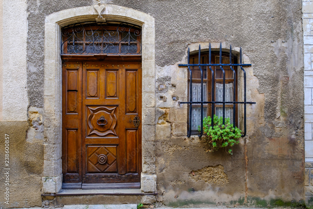 Façade d'une maison en Provence, France. Porte en bois sculpté, petite  fenêtre, bac avec des fleurs. Stock Photo | Adobe Stock