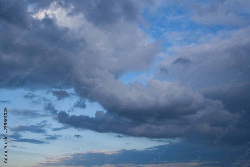 Low leaden storm clouds in the blue sky background Low leaden storm clouds in the blue sky background
