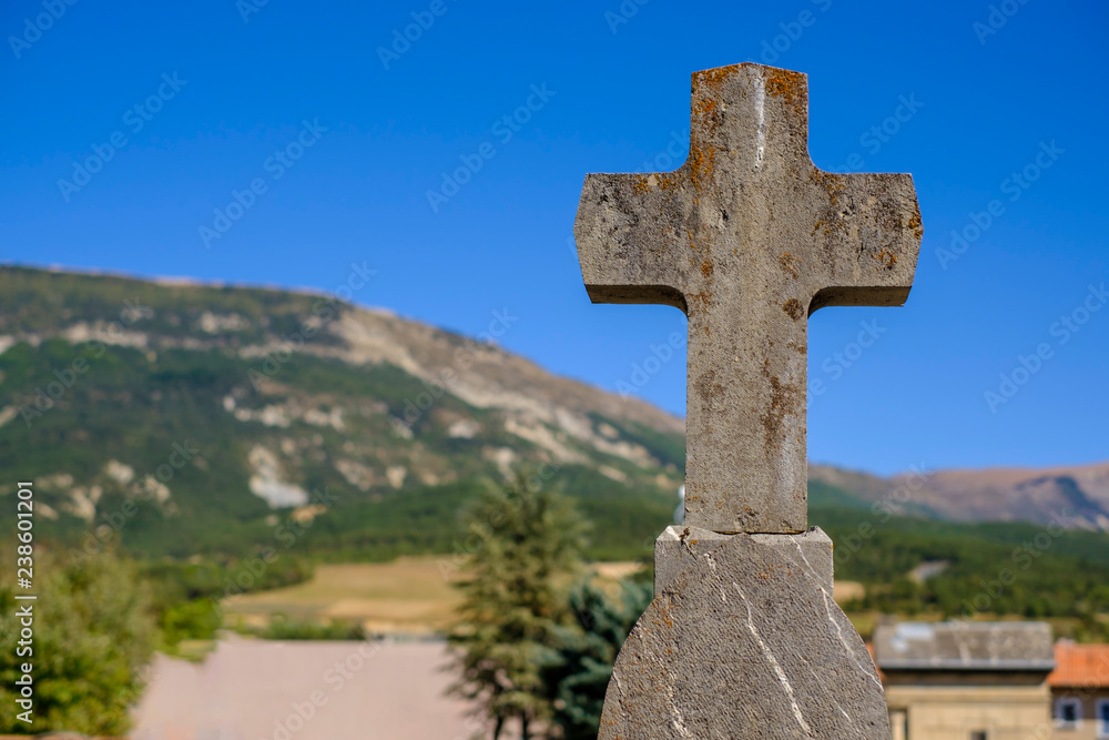 Croix en pierre dans la cimetière catholique. Les montagnes en arrière-plan. 