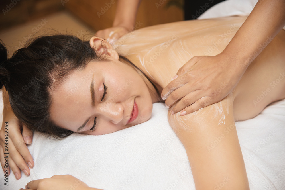 Beautiful young asia woman smile getting spa massage salon on white bed Beautiful young asia woman smile getting spa massage salon on white bed