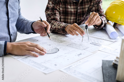 Construction engineering or architect discuss a blueprint while checking information on drawing and sketching meeting for architectural project in work site