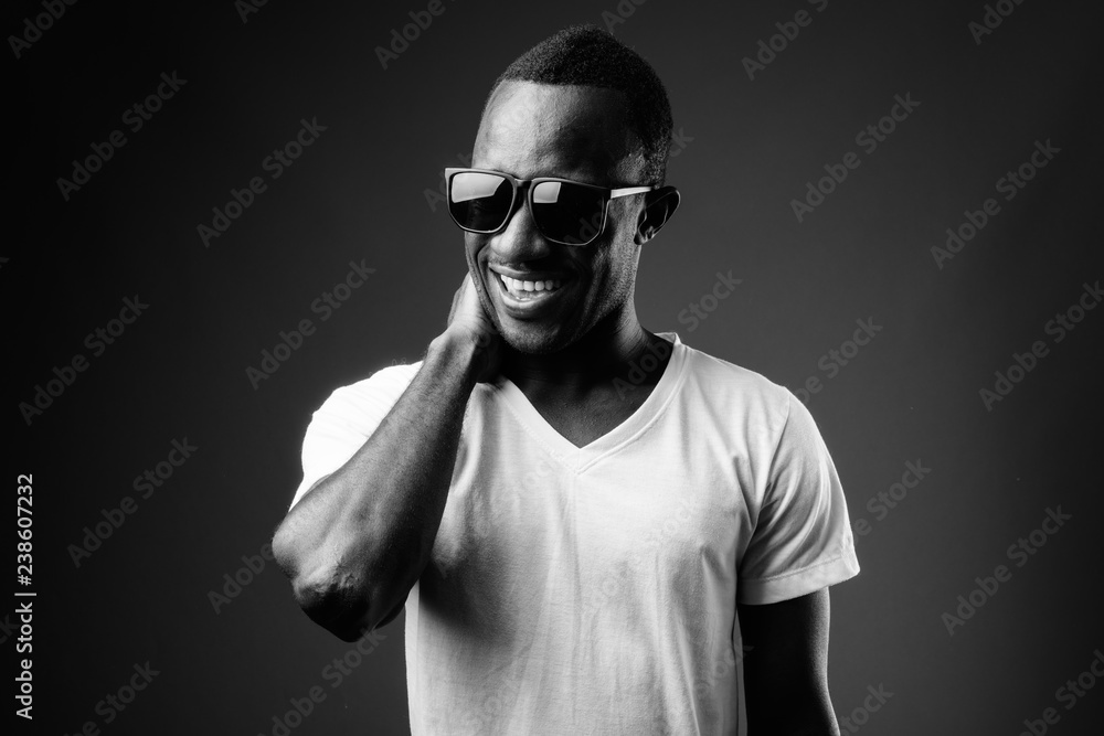 Young African man wearing sunglasses and laughing