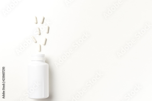 Assorted pharmaceutical medicine pills, tablets and capsules and bottle on white background. Top view. Flat lay. Copy space. Medicine concept. Heap of pills on white background