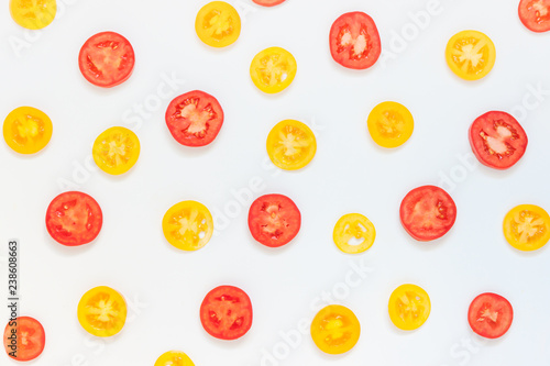 Red and yellow tomato slices on white background. Top view. © Kat Ka