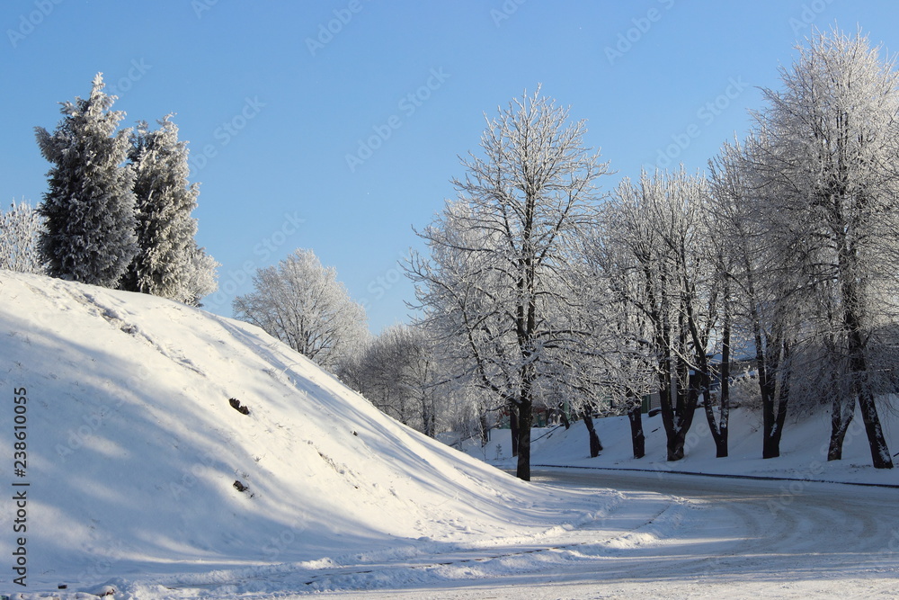 Winter road trip and beautiful icy trees on snowy hill on blue sky background on sunny day - winter lanscape Winter road trip and beautiful icy trees on snowy hill on blue sky background on sunny day - winter lanscape