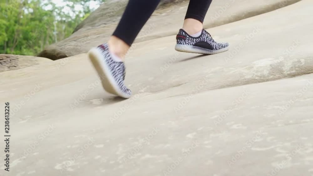 Legs of young woman walking through the mountain. Teenage girl wearing sports clothes. Climbing concept. Out of town. Outdoors. Legs of young woman walking through the mountain. Teenage girl wearing sports clothes. Climbing concept. Out of town. Outdoors.