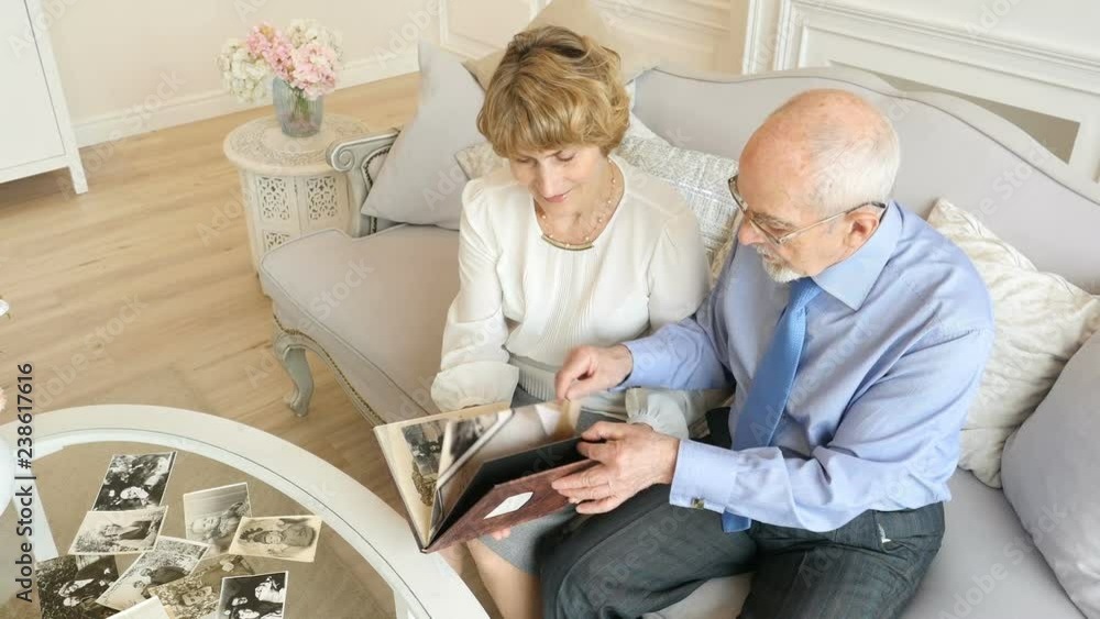 Happy caucasian elderly couple spending time together and watching old photos Happy caucasian elderly couple spending time together and watching old photos