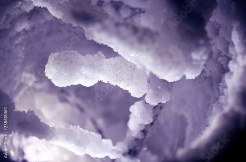 Crystals of salt on a glass and a branch, similar to snow, top view on dark background closeup