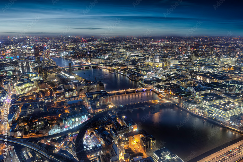Fototapeta premium Widok z lotu ptaka na panoramę Londynu wzdłuż Tamizy ze słynnymi mostami i atrakcjami wieczorem
