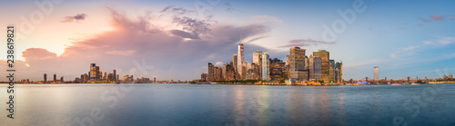Canvas-taulu New York City financial district skyline panorama from across the harbor at dusk