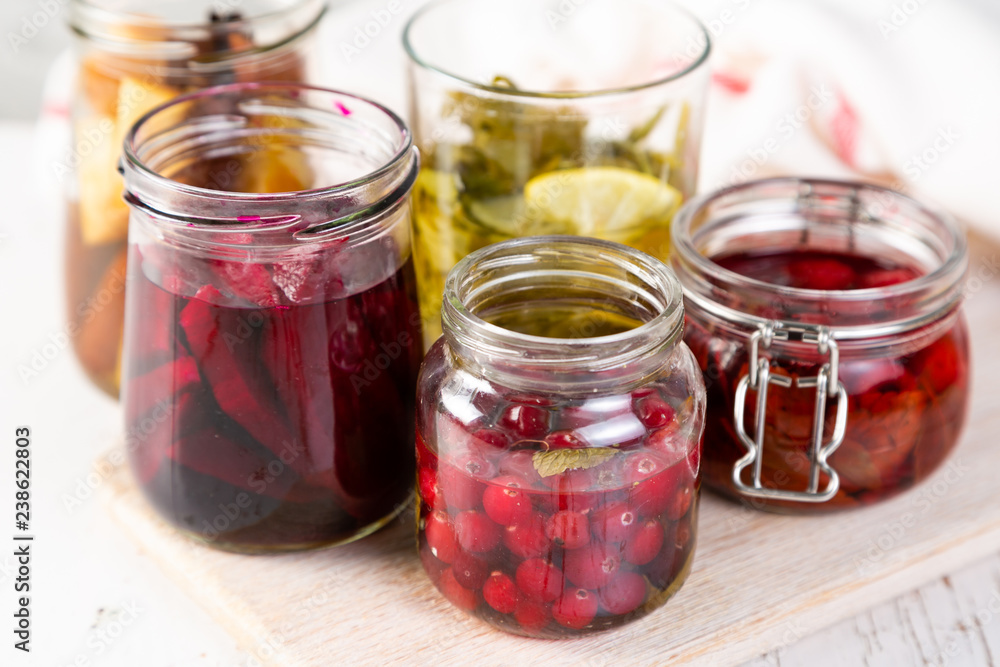 Preparing drinking vinegar infusions in glass jars, copy space