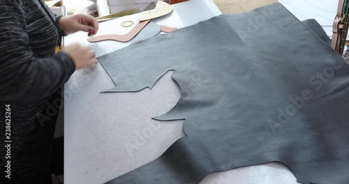 Shoemaker master cutting shoe leather as template, clicking the upper in a shoes factory.4k