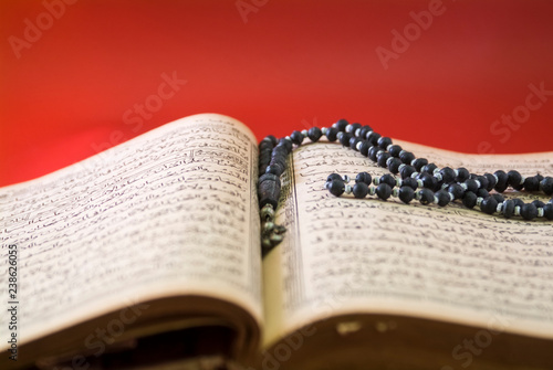 An open Koran with prayer beads on it