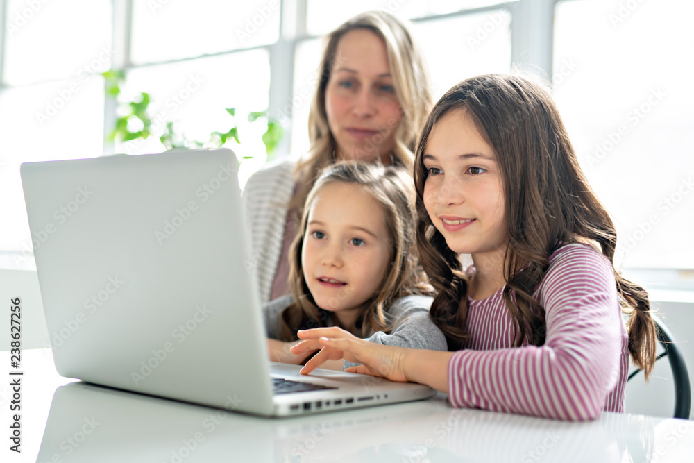 A Nice mom spend time with kids watching educational programs on laptop A Nice mom spend time with kids watching educational programs on laptop