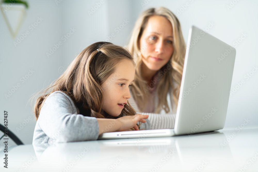 A Nice mom spend time with kid watching educational programs on laptop