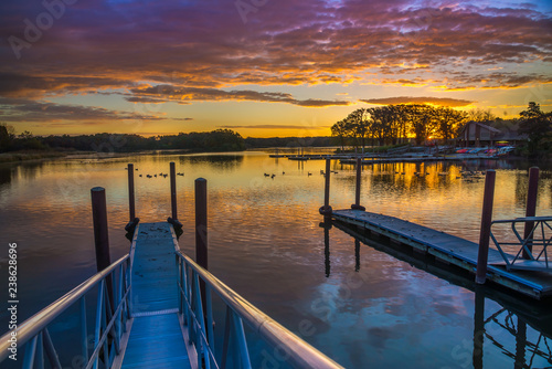 Fototapeta Naklejka Na Ścianę i Meble -  Beautiful sunset over lake, wooden walkways with railing