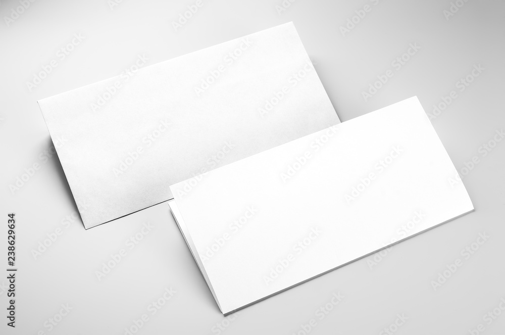 Blank envelope and folded letterhead over gray background Blank envelope and folded letterhead over gray background