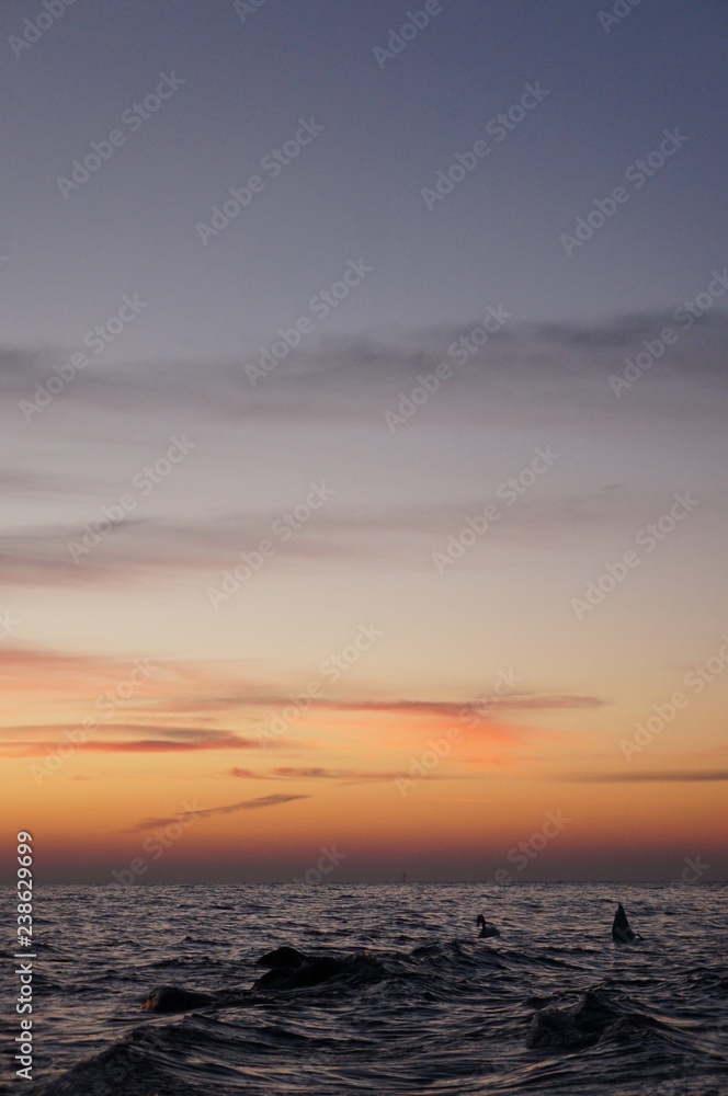 Sonnenuntergang am Strand mit Wellen und Sand an der Ostsee nahe Warnemünde im Urlaub
