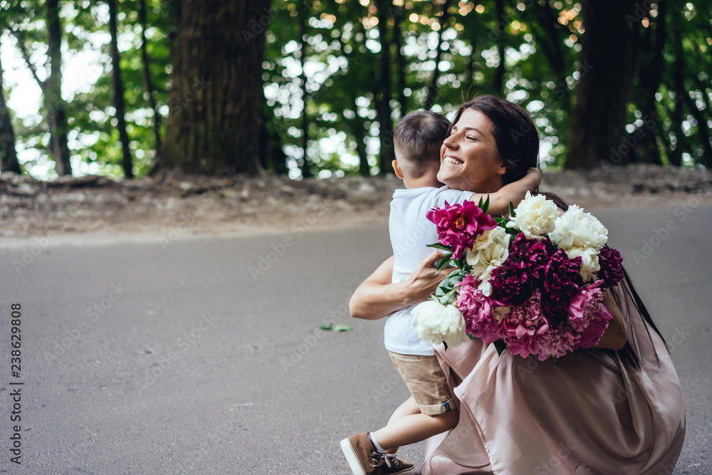 Fototapeta premium Happy mother with her young son in a summer park.