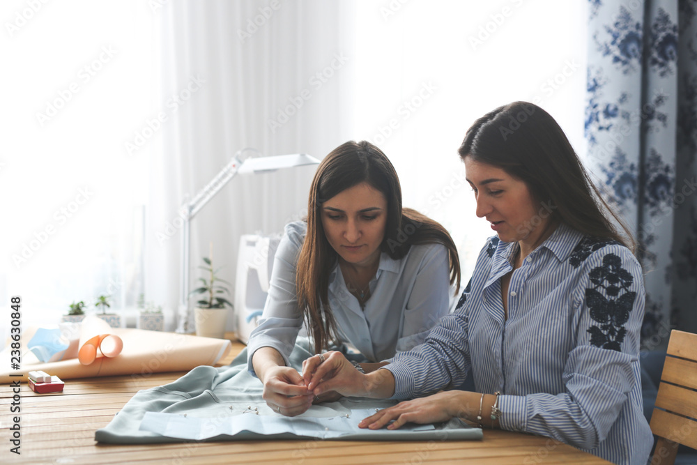 two beautiful women work with pattern and fabric two beautiful women work with pattern and fabric