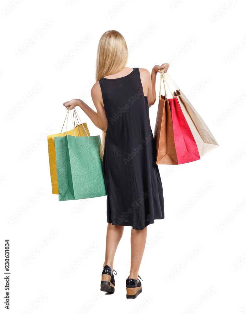 back view of woman with shopping bags . beautiful brunette girl in motion.  backside   person.