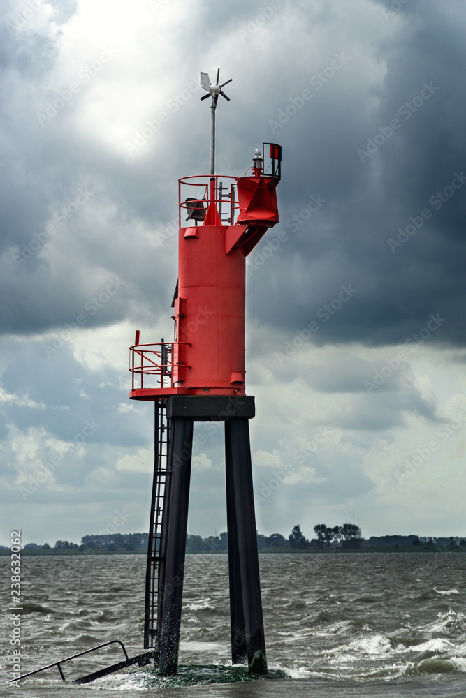 A big red buoy as a navigational marker in the Northern Sea in Germany.