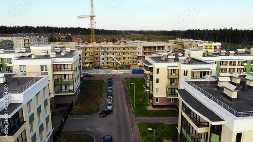 Aerial view on buildings under construction, crane with cargo