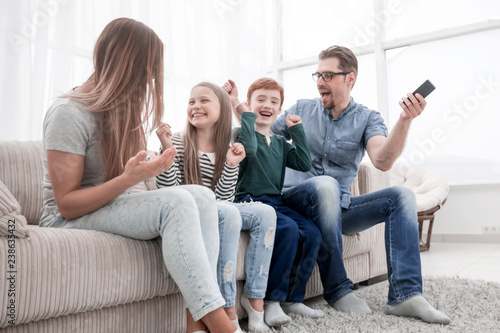 happy family sitting watching TV in their home