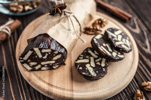 Chocolate sachocolate; sausage; background; wooden; baked; biscuit; board; breakfast; brown; butteusage on a wooden background. Dessert made of biscuits, chocolate and nuts is sliced on a wooden board