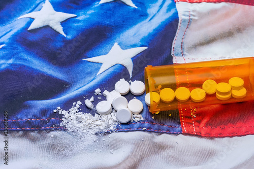 Opioid and drug addiction epidemic concept on USA flag with pills and bottle and room for copy text