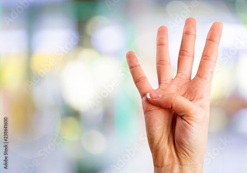 Young woman showing four fingers with hand photo