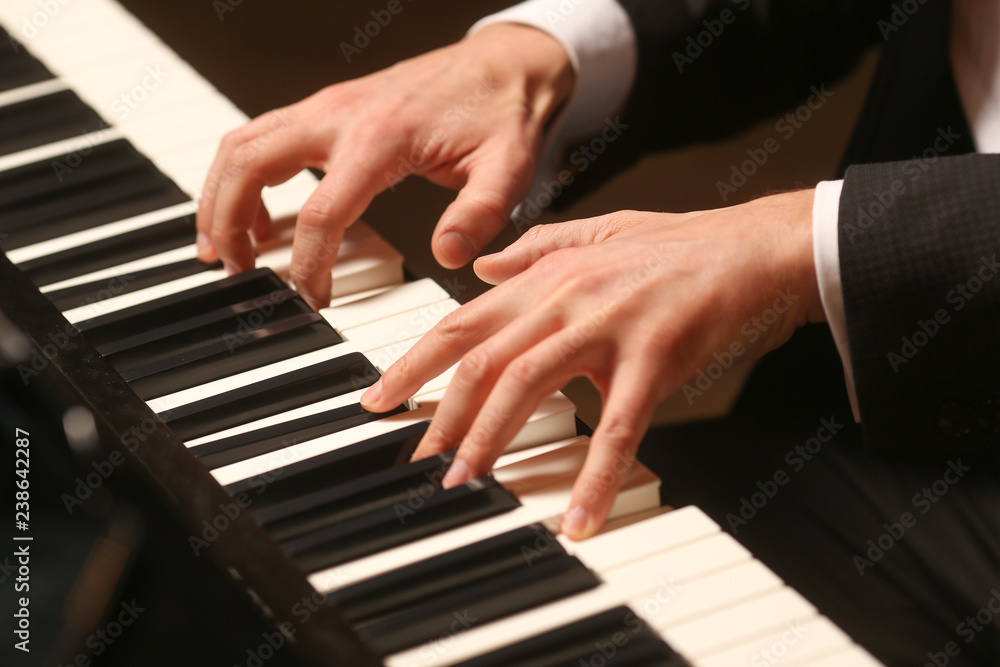 Hands on piano. The pianist plays the piano. Piano keys on black background Hands on piano. The pianist plays the piano. Piano keys on black background