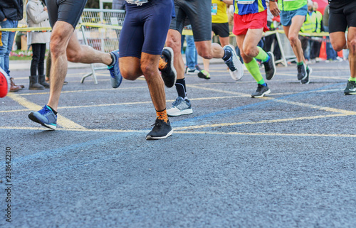 Marathon race, feet of people running on city road