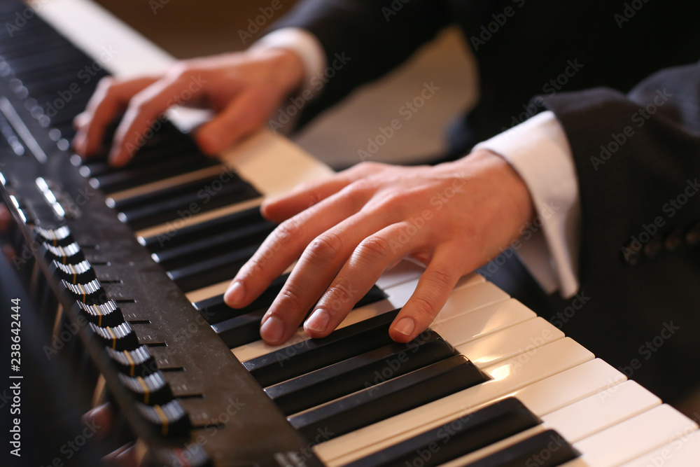 Hands on piano. The pianist plays the piano. Piano keys on black background Hands on piano. The pianist plays the piano. Piano keys on black background