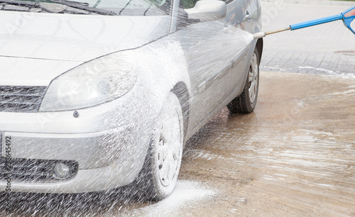 Car wash with foam in car wash station. Carwash. Washing machine at the station. Car washing concept. Car in foam photo