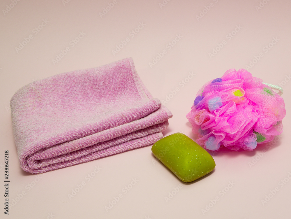 bathroom shower stuff on pink background - green soap with aloe essence, towel and sponge bathroom shower stuff on pink background - green soap with aloe essence, towel and sponge