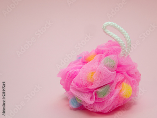 closeup fancy fluffy pink sponge on pink background with colored inserts